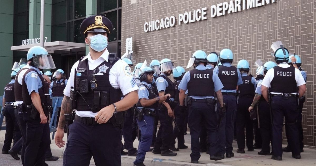 Chicago police stand guard as demonstrators protest outside the department's 7th District station on Aug. 11, 2020.