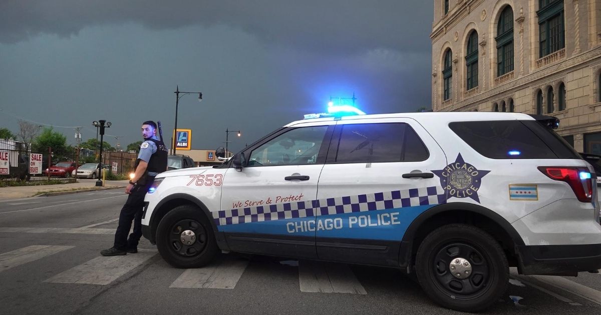 A police officer stands guard following violent unrest in Chicago moments before a derecho storm hits the area on Aug. 10, 2020.