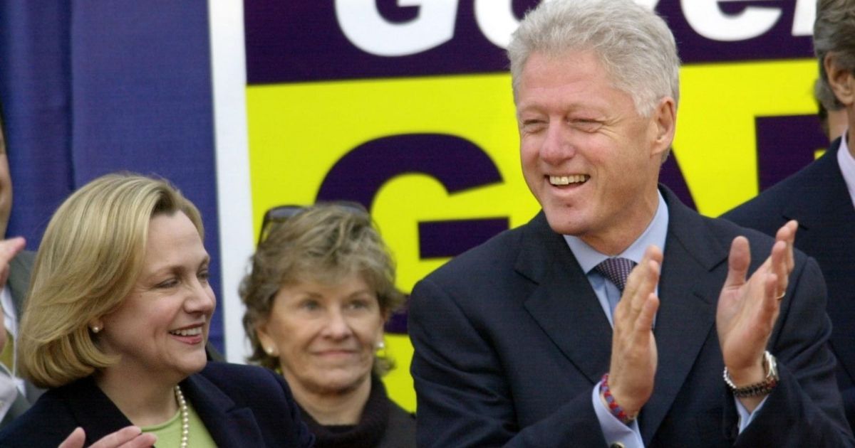 Former President Bill Clinton reacts to supporters at a rally in 2002, the year he flew to Africa on a humanitarian mission in which he received a neck massage from a woman who accused Jeffrey Epstein of rape.