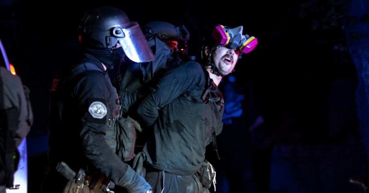 A protester is arrested during a standoff with police in Portland, Oregon, on Aug. 16, 2020.