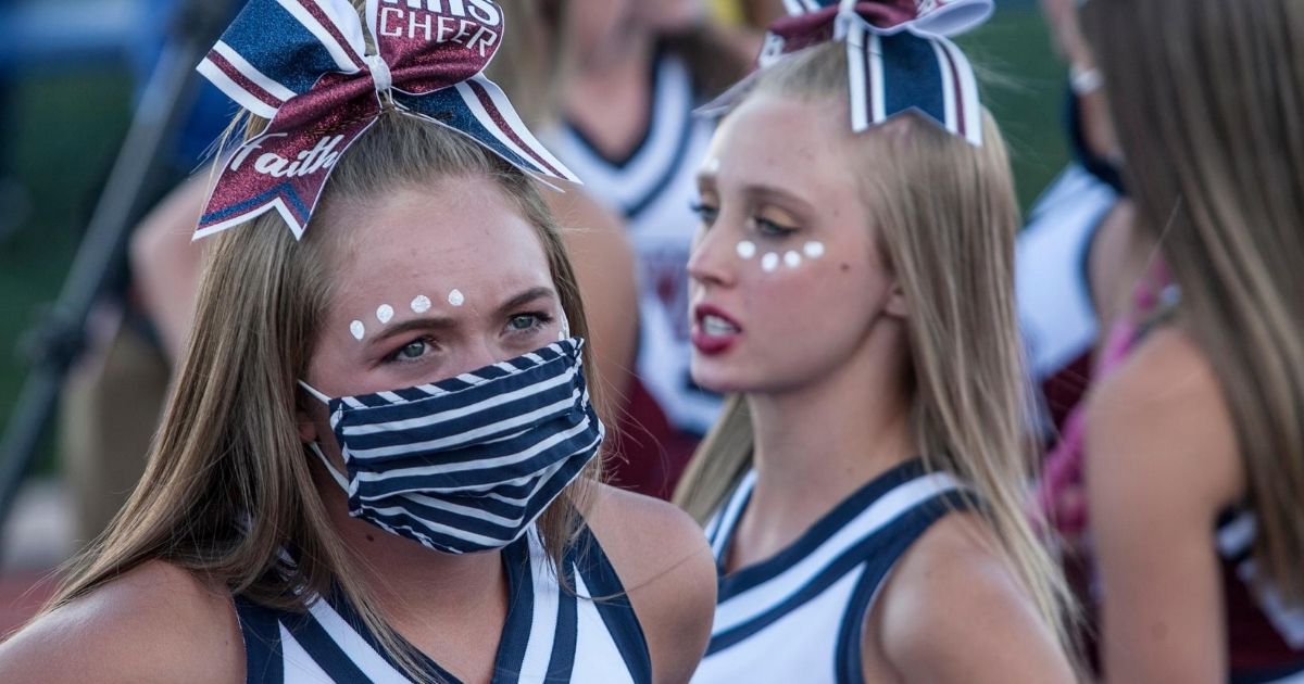 A high school cheerleader wears a mask for her school's football game in Herriman, Utah, on Aug. 13, 2020. It was the first high school football game in the country this season amid the coronavirus pandemic.