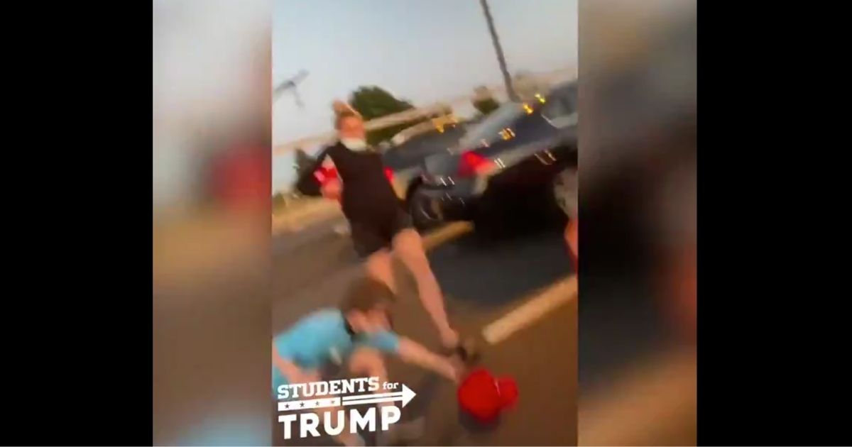 A woman kicks a 7-year-old boy's MAGA hat away from him in parking lot in Wilmington, Delaware.