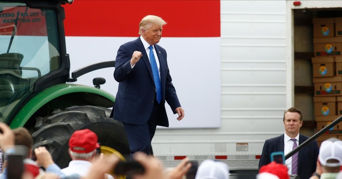President Donald Trump greets supporters with a fist pump during a tour of a packing plant in Mills River, North Carolina, on Monday.