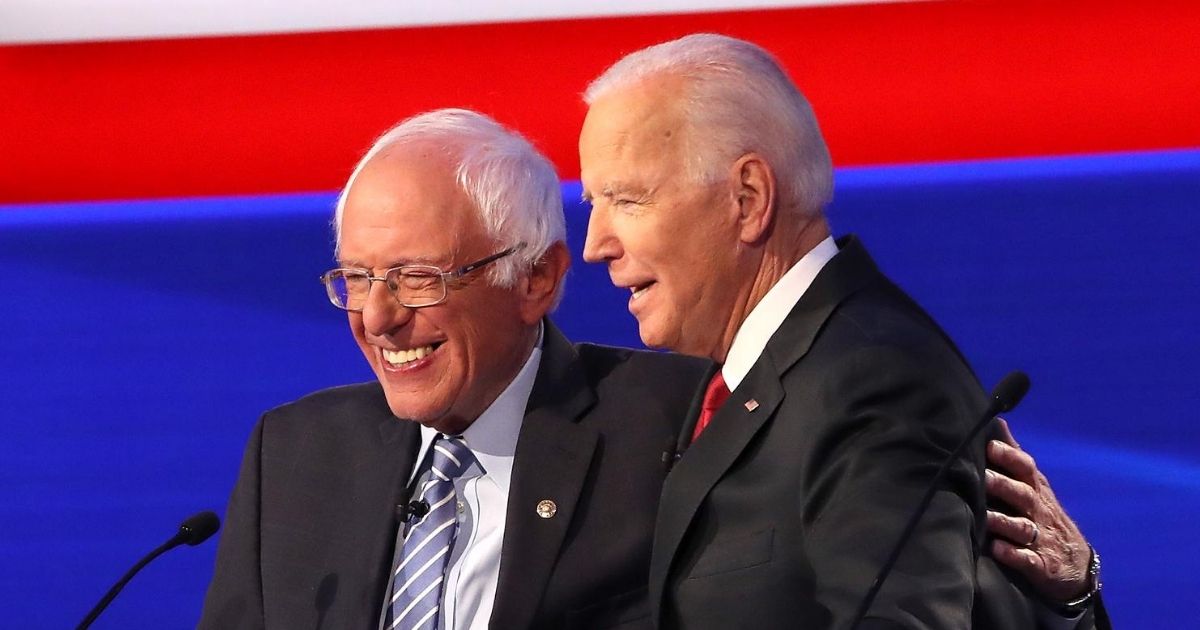 Independent Sen. Bernie Sanders of Vermont and former Vice President Joe Biden put their arms around each other during the Democratic Presidential Debate at Otterbein University on Oct. 15, 2019, in Westerville, Ohio.