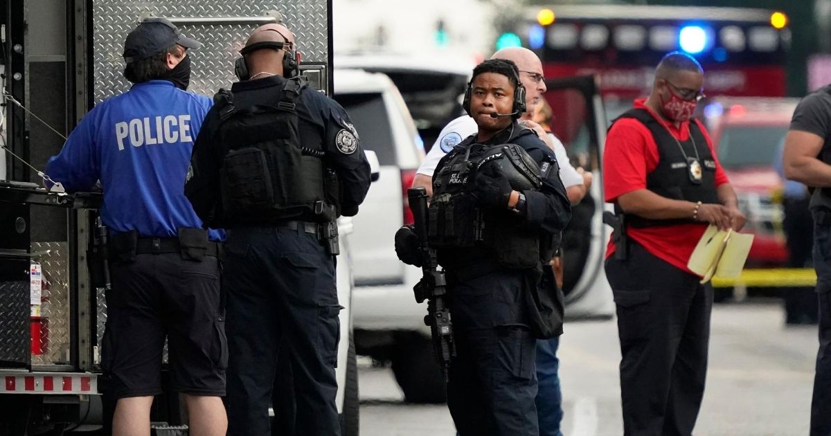 Police officers set up near the scene of a shooting that left two of their colleagues wounded Saturday in St. Louis.