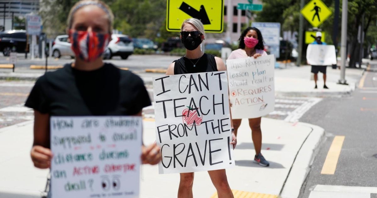 Teachers protest in front of the Hillsborough County School District Office on July 16, 2020, in Tampa, Florida. Teachers and administrators from the school system rallied against the reopening of schools due to health and safety concerns amid the COVID-19 pandemic.