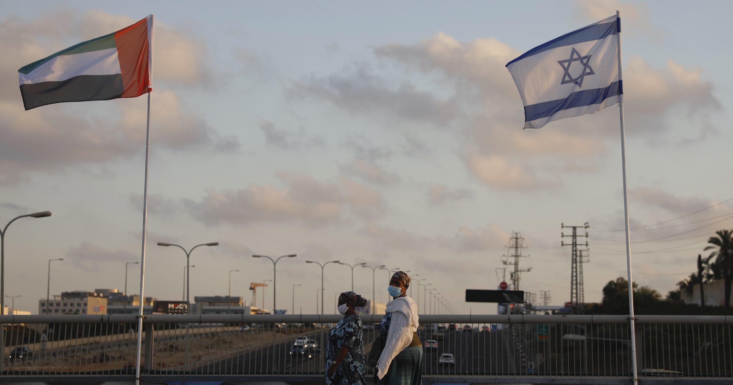 Women walk past United Arab Emirates and Israeli flags at the Peace Bridge in Netanya, Israel, on Aug. 16, 2020. The UAE flag was displayed to celebrate last week's announcement that Israel and the United Arab Emirates have agreed to establish full diplomatic relations.