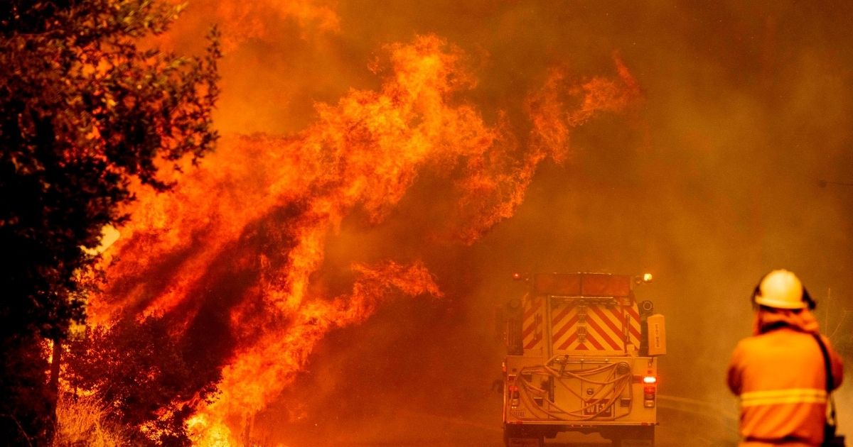 A fire truck drives through flames as a fire rages out of control near Lake Berryessa in Napa, California, on August 18, 2020.