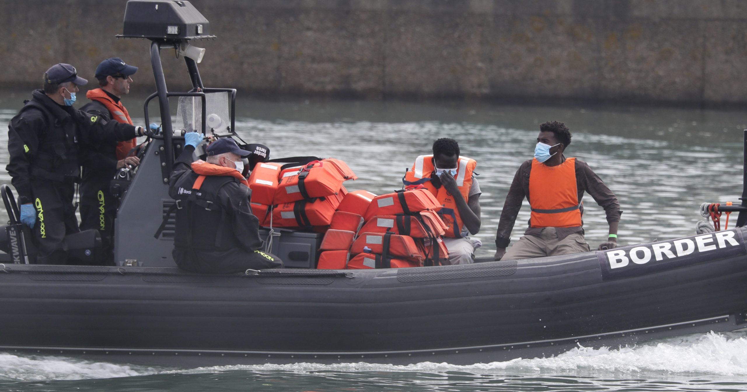 A Border Force vessel brings a group of people thought to be migrants into the port city of Dover, England, on Aug. 8, 2020. The British government says it will strengthen border measures as calm summer weather has prompted a record number of people to attempt the risky sea crossing from northern France to England.