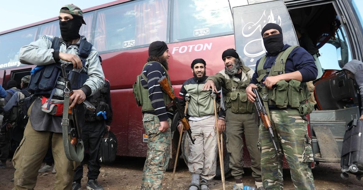 Fighters from Hayat Tahrir al-Sham and members of their families arrive in a rebel-held area of Syria's northern Aleppo province on May 1, 2018.