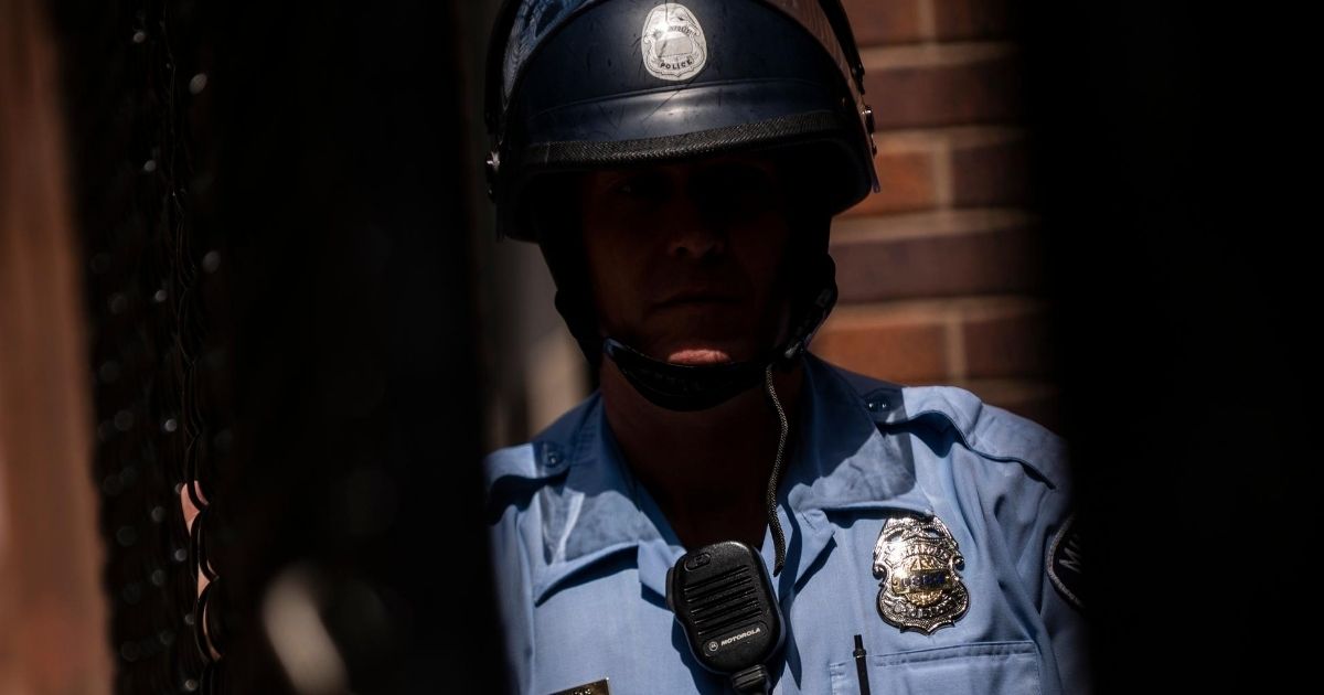A member of the Minneapolis Police Department is seen through a chain link gate on June 13, 2020, in Minneapolis, Minnesota.