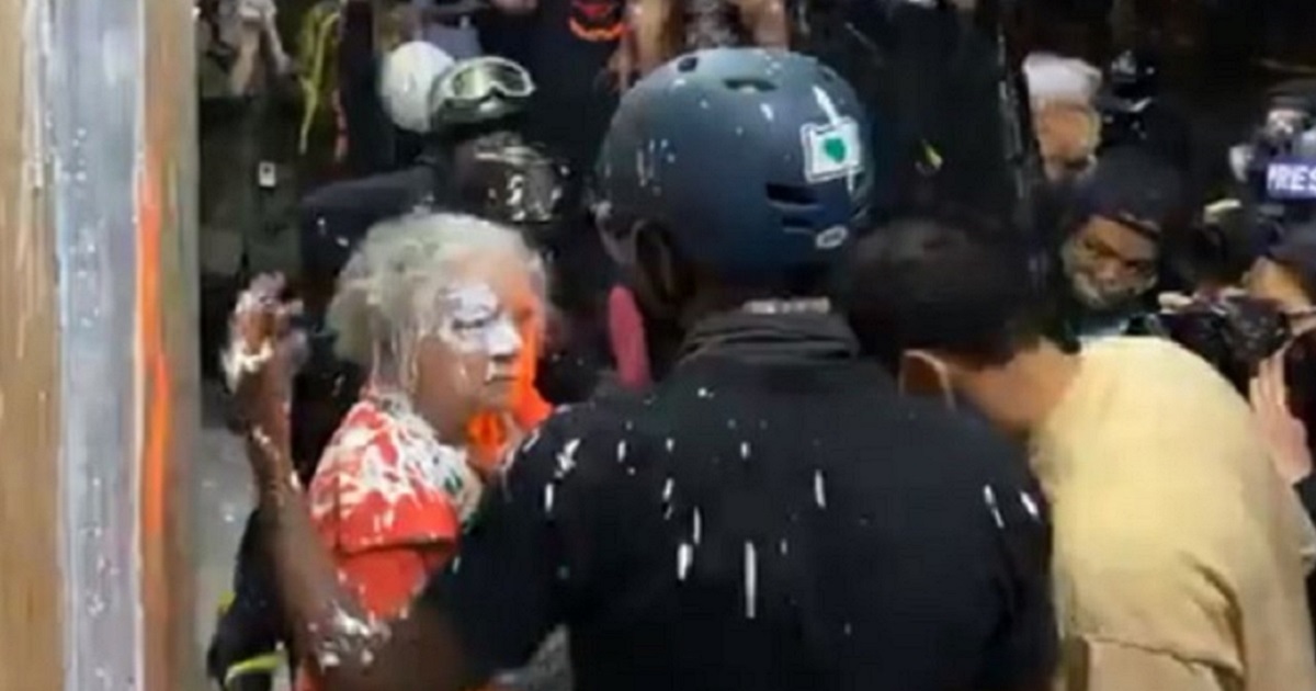 An elderly woman is berated by an antifa rioter after she was smeared with paint during rioting Thursday night.