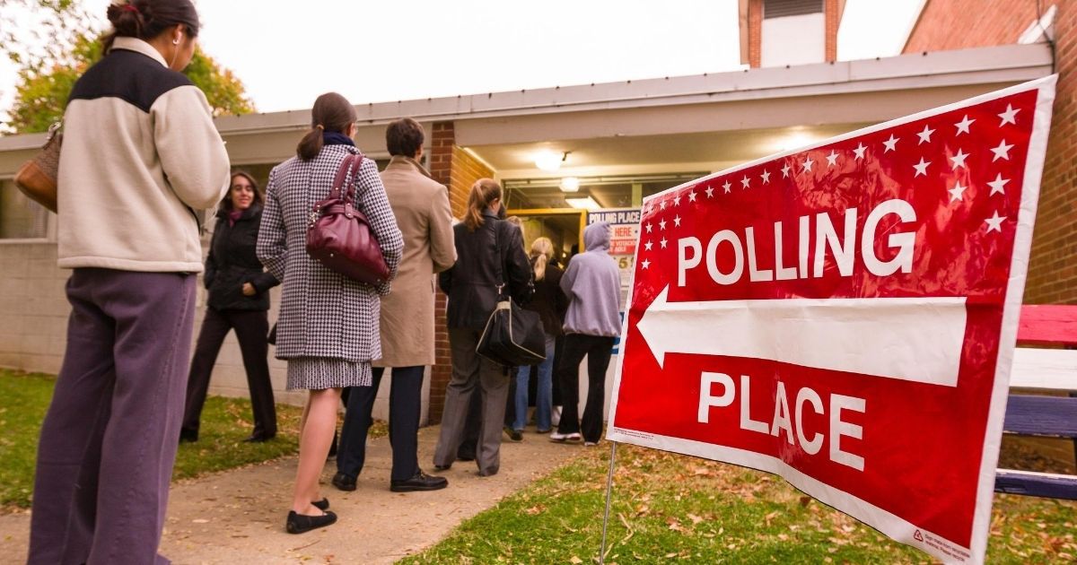Voters wait on line outside a polling location in the stock image above.