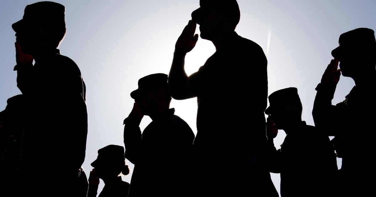 Saluting soldiers are seen in this stock image.