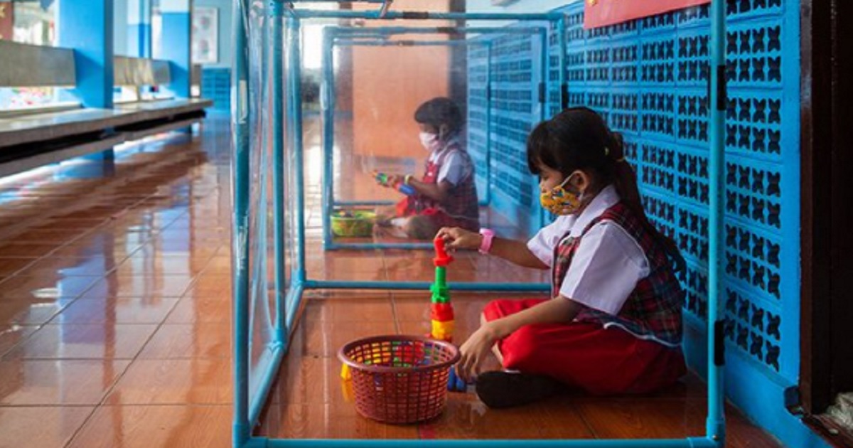 Children at a school in Bangkok, Thailand, sit in plastic isolation pods during playtime to be protected from coronavirus infection.
