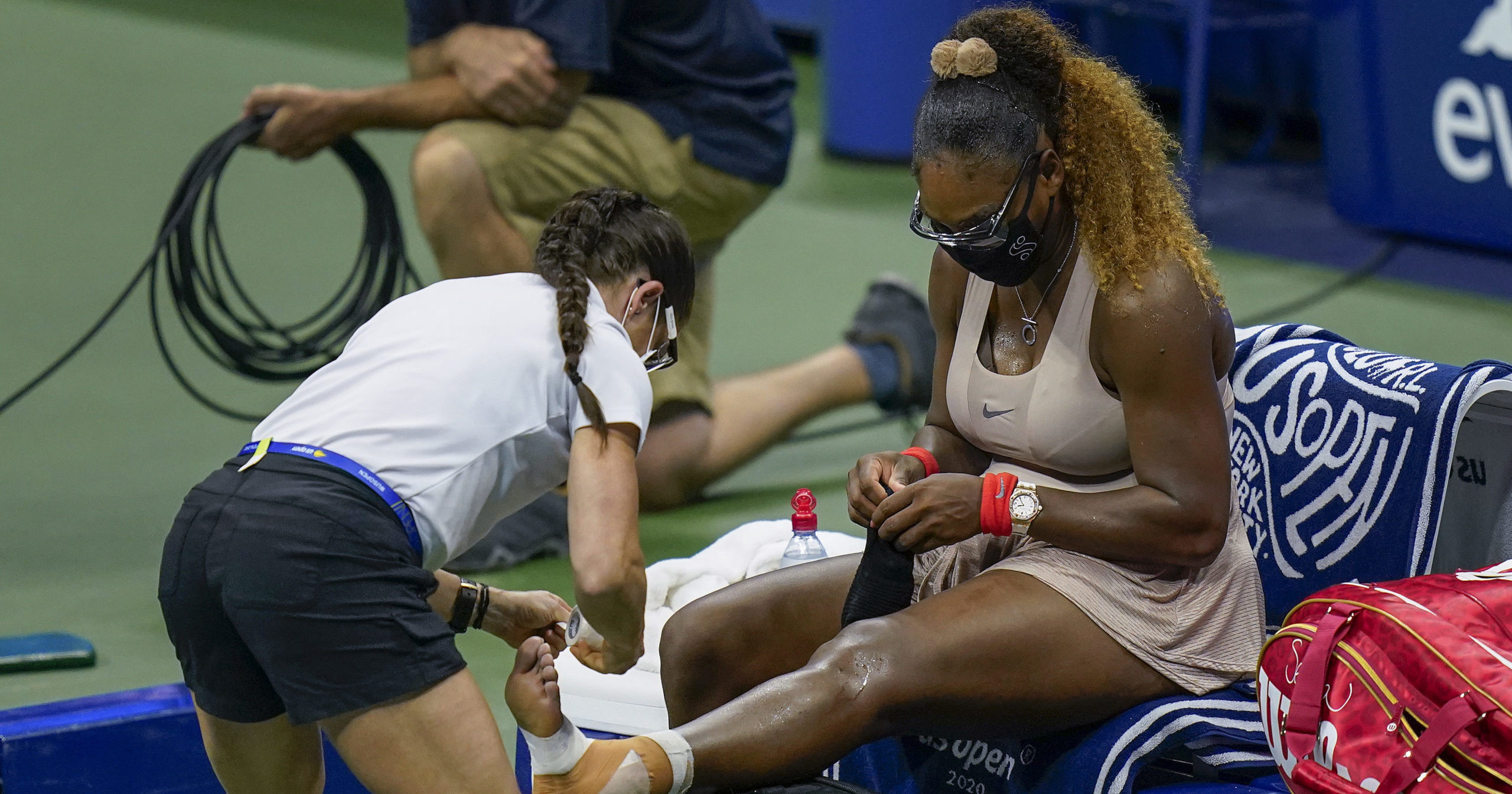 Serena Williams, of the United States, has her ankle taped by a trainer during a medical timeout during a semifinal match of the US Open tennis championships against Victoria Azarenka, of Belarus on Sept. 10, 2020, in New York