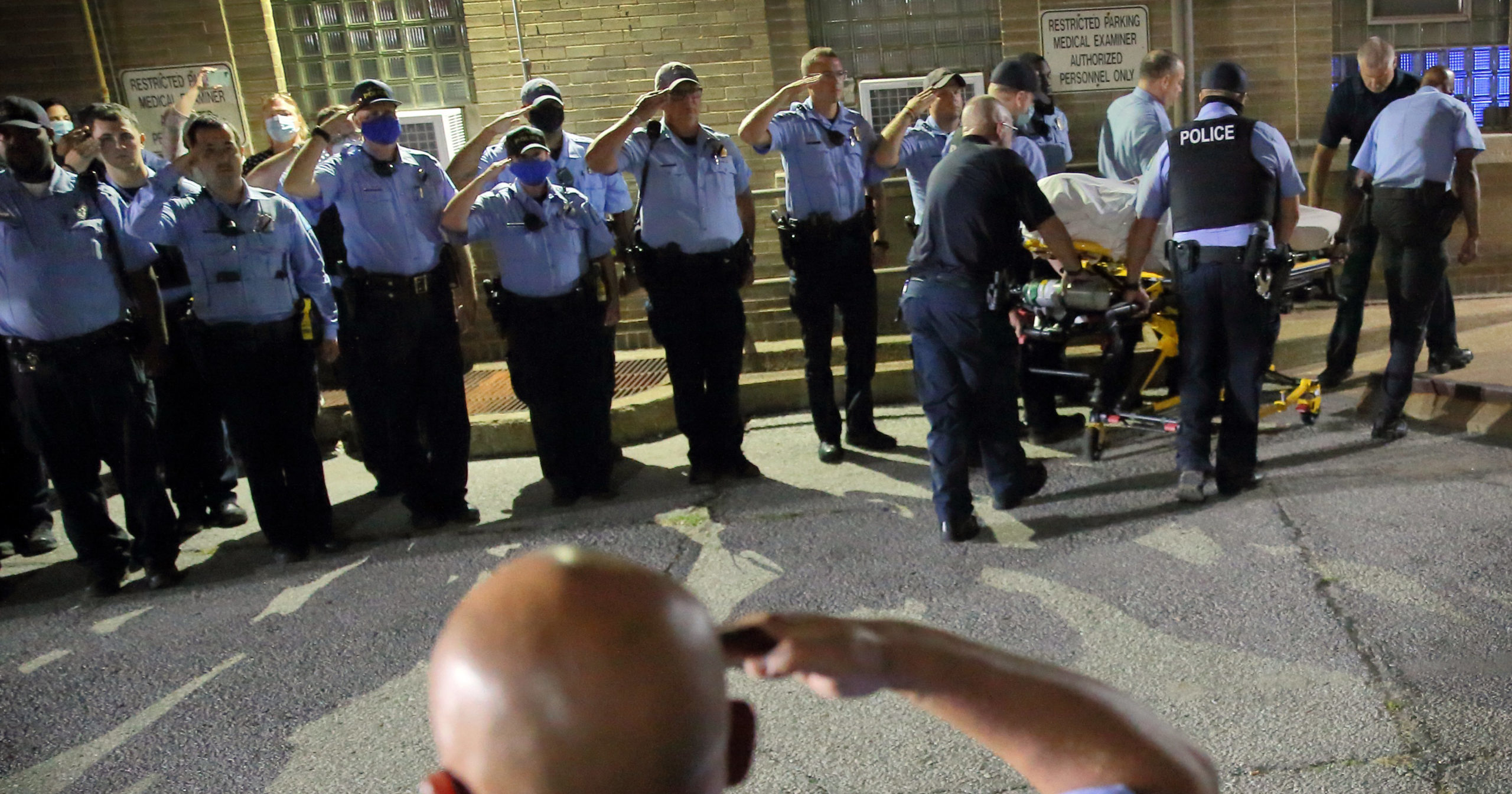 St. Louis police officers line up and salute as the body of fallen officer Tamarris L. Bohannon is brought to the morgue in St. Louis on Aug. 30, 2020. Bohannon died after being shot in the head by a barricaded gunman on the city's south side, authorities said.