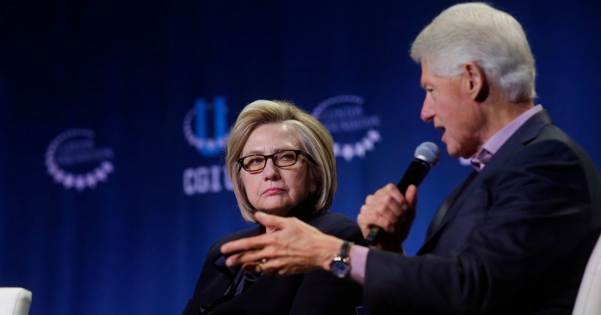 Former Secretary of State Hillary Clinton listens as former President Bill Clinton speaks during the annual Clinton Global Initiative conference at the University of Chicago on Oct. 16, 2018, in Chicago.