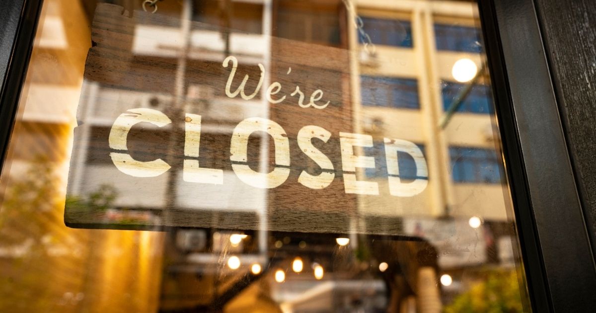A closed sign hangs in a business in the stock image above.