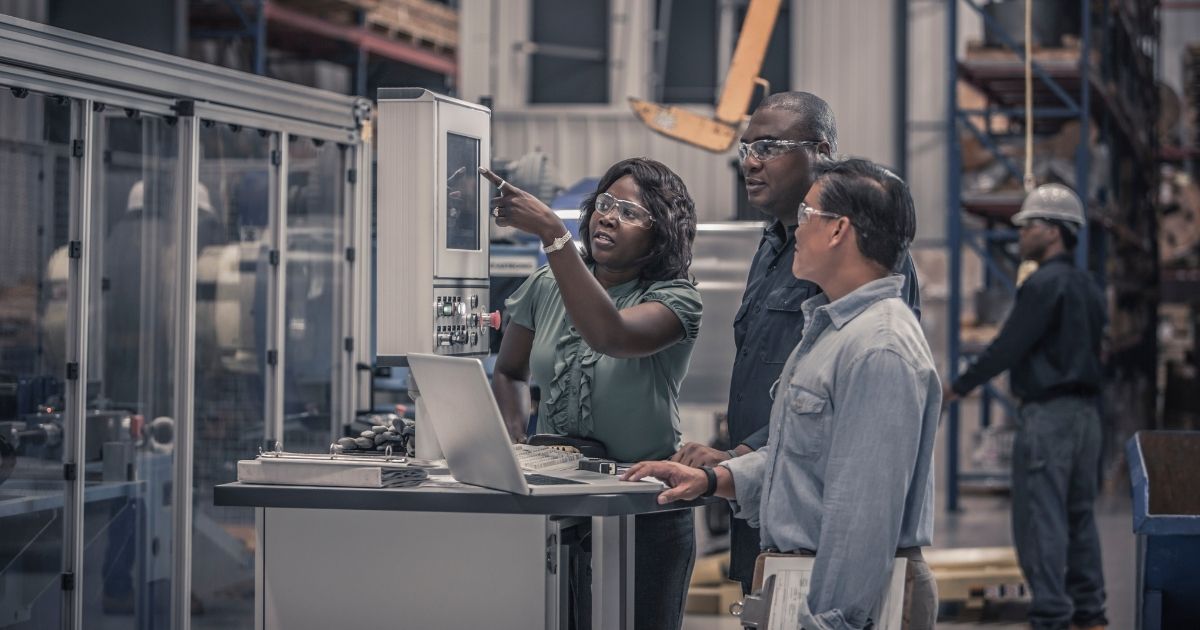 Workers talk in a factory in the stock image above.