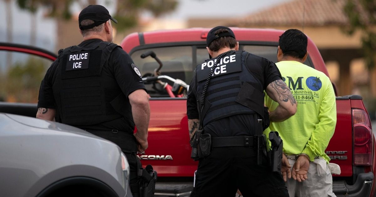 In this July 8, 2019, photo, a U.S. Immigration and Customs Enforcement officers detain a man during an operation in Escondido, California.