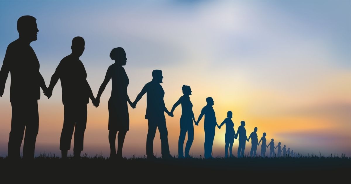 A group of people stand together as a human chain in the above stock photo.