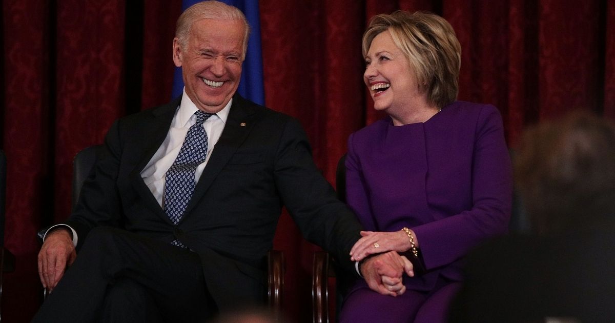 Former Secretary of State Hillary Clinton, right, shares a moment with Vice President Joseph Biden during a leadership portrait unveiling ceremony for Senate Minority Leader Sen. Harry Reid on Dec. 8, 2016, on Capitol Hill in Washington, D.C.