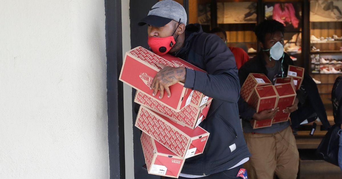 In this May 31, 2020, file photo, items are taken from a Vans store in Santa Monica, California, during unrest and protests over the death of George Floyd.