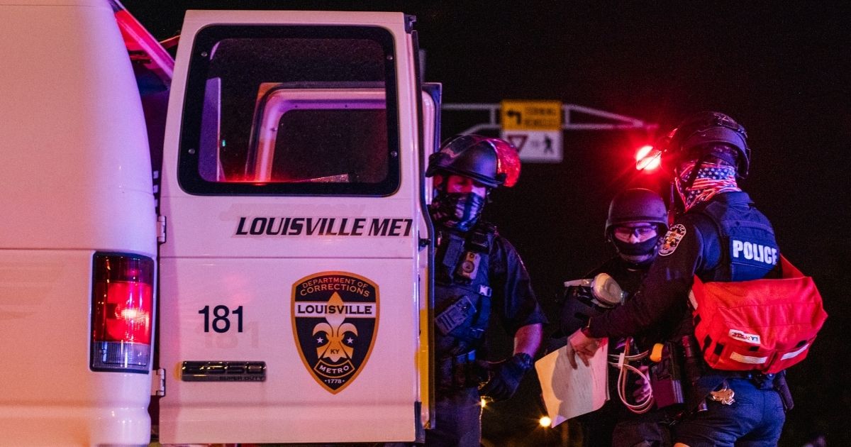 Police officers put a protester in the back of a police vehicle on Sept. 26, 2020, in Louisville, Kentucky.