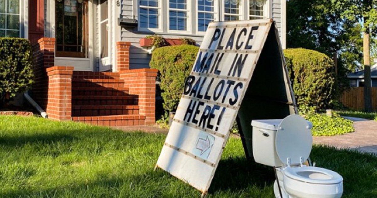 A toilet with a "place mail in ballots here" sign adorns a lawn in Mason, Michigan.
