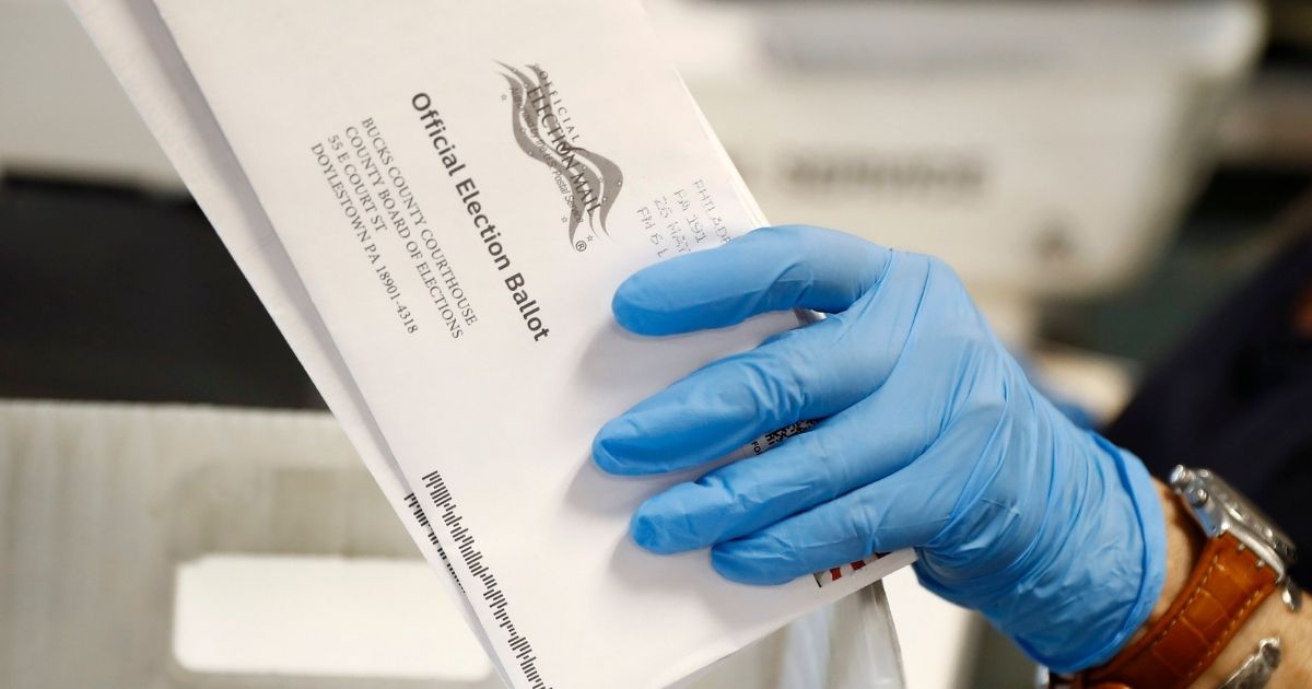 In this May 27, 2020, file photo, a worker processes mail-in ballots at the Bucks County Board of Elections office prior to the primary election in Doylestown, Pennsylvania.