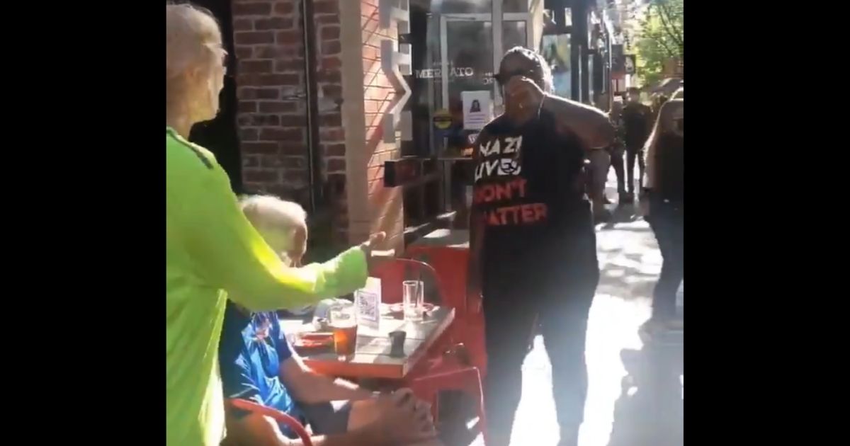 A protester in Pittsburgh steals a drink from a restaurant patron.