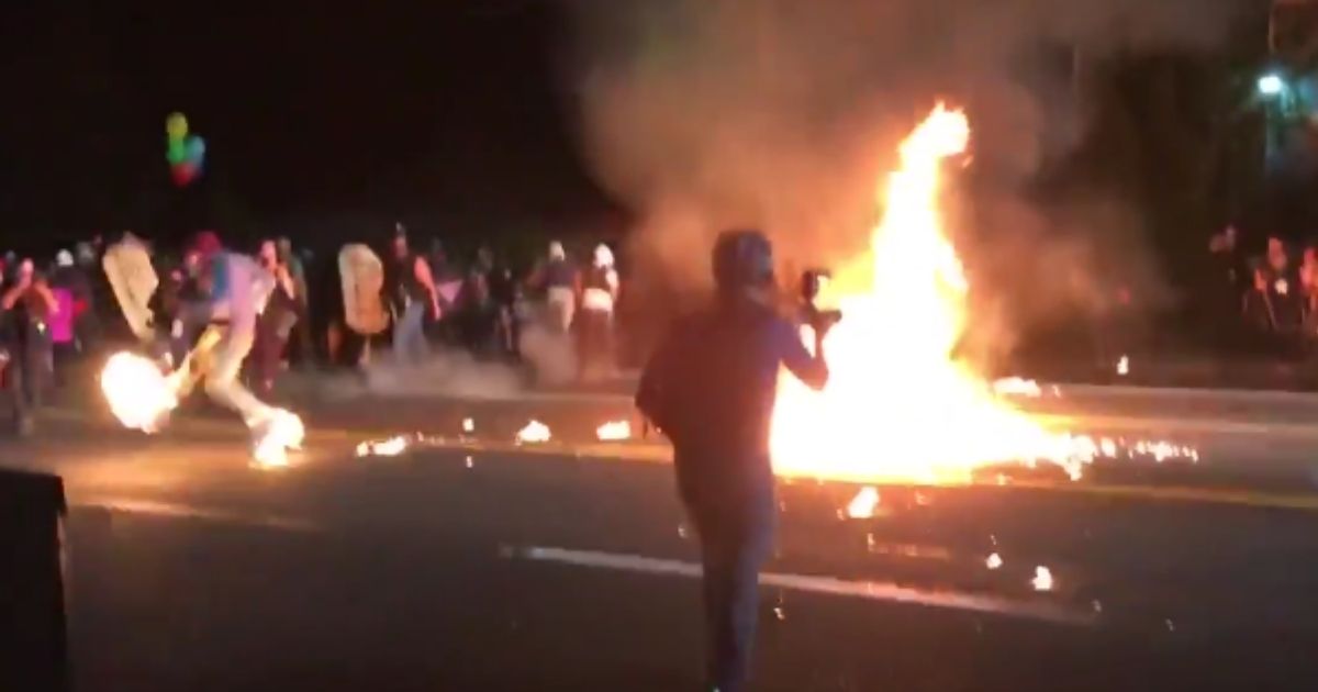 A Portland protester accidentally lit another protester's shoes on fire when throwing a Molotov cocktail at police Sept. 5, 2020.