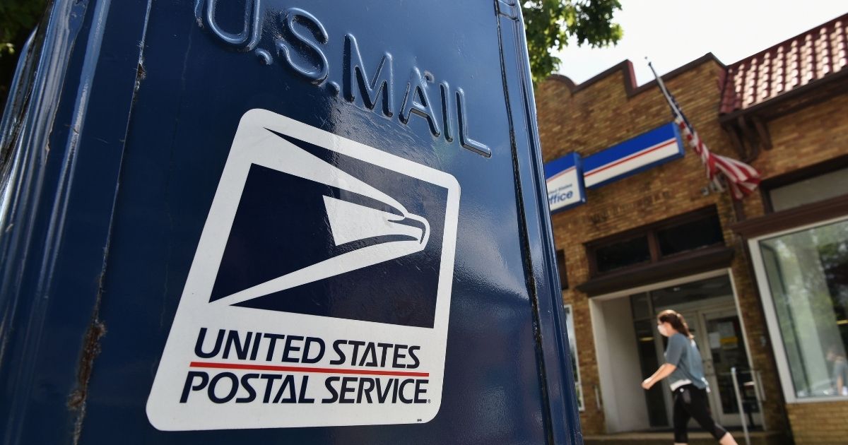 A woman walks past a mailbox outside of a post office in Washington, D.C., on Aug. 17, 2020.