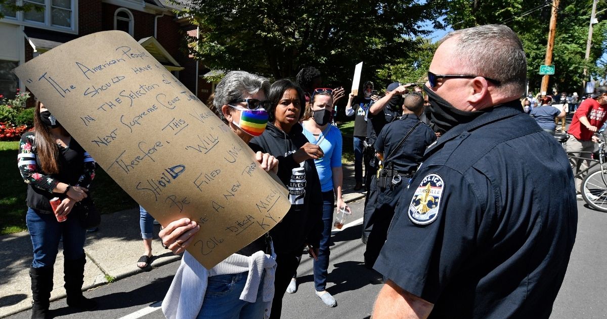 Louisville Metro police officers attempt to get protesters out of the street during a rally outside the house of Senate Majority Leader Mitch McConnell in Louisville, Kentucky, on Sept. 19, 2020.