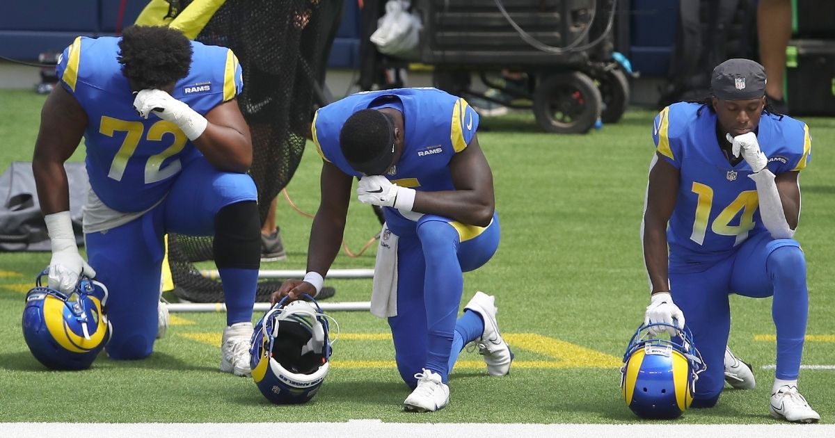 Tremayne Anchrum, left, Bryce Perkins, center, and Nsimba Webster of the Los Angeles Rams kneel during the national anthem prior to a team scrimmage at SoFi Stadium in Inglewood, California, on Aug. 29, 2020.