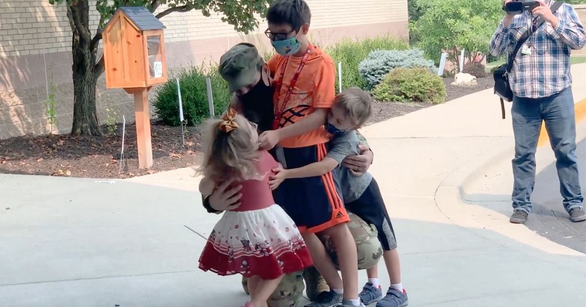 Sgt. Kirby Karnes hugs his children after being deployed for 311 days.
