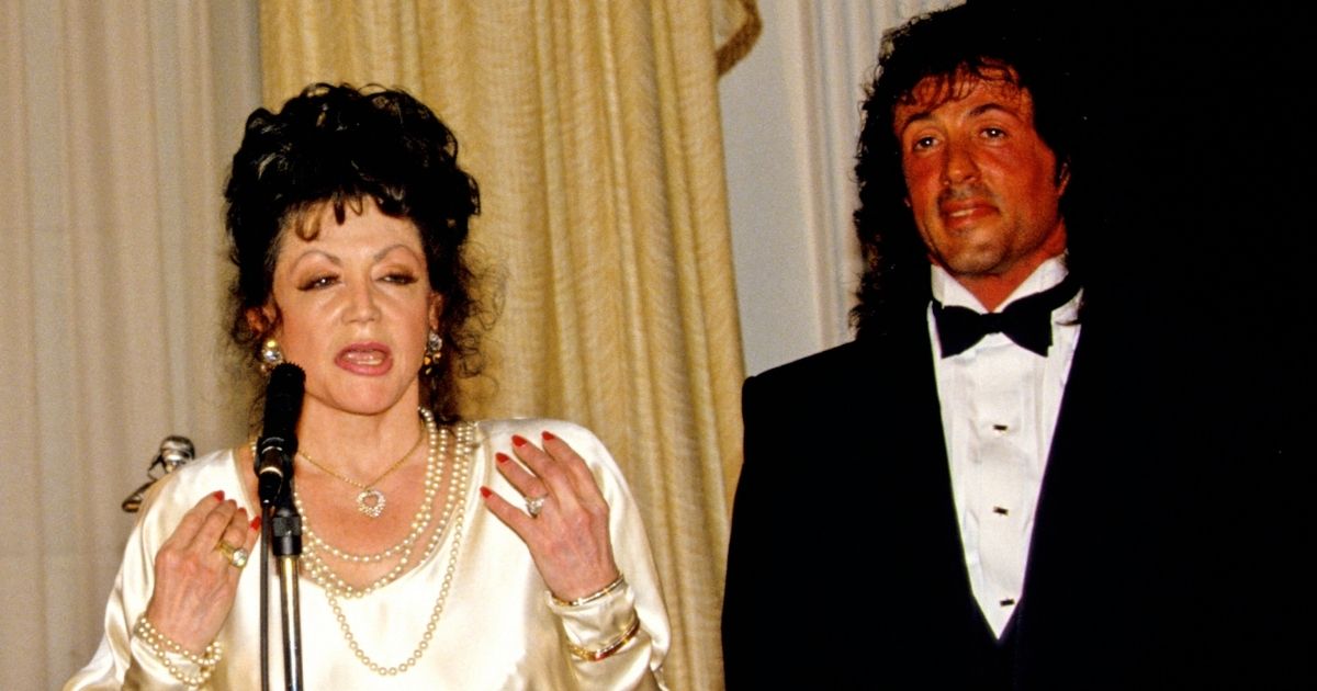 Sylvester Stallone watches while his mother, Jackie Stallone, speaks during the Washington Touchdown Club's awards dinner at the Omni Shoreham Hotel in Washington, D.C., on Jan. 23, 1988.