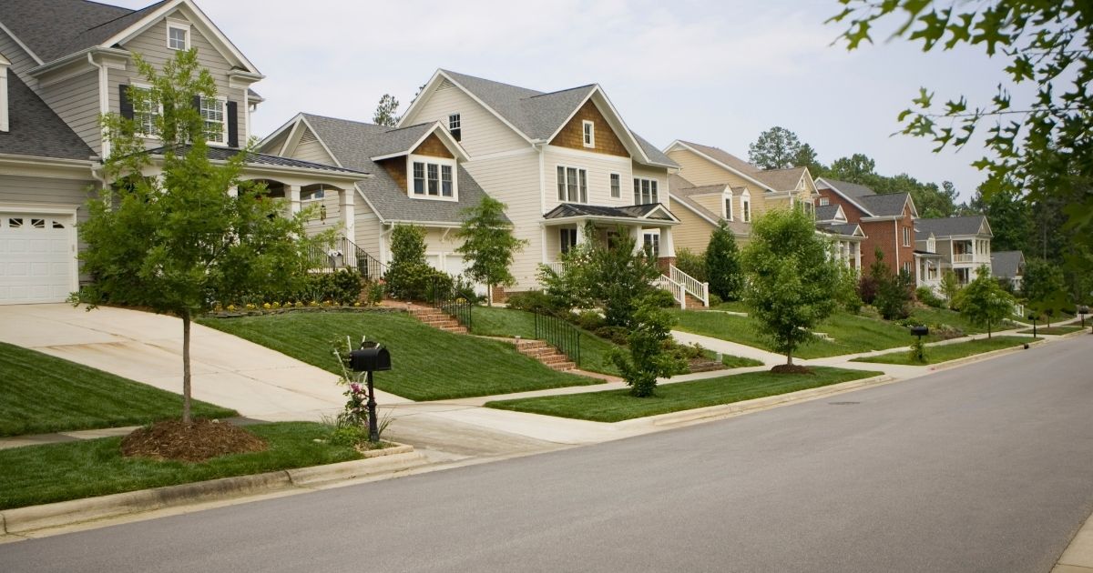 A row of houses in a suburban neighborhood is shown in the above stock photo.