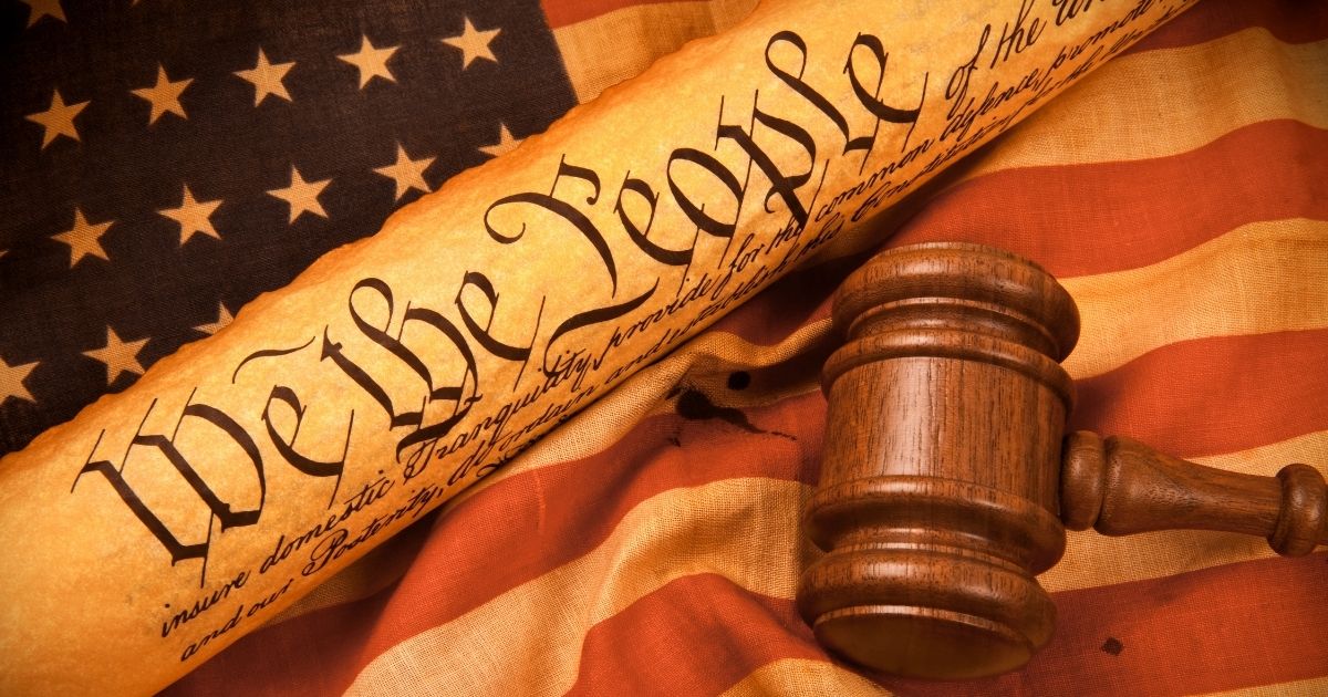 A stock image of the Constitution against an American flag background is pictured above.