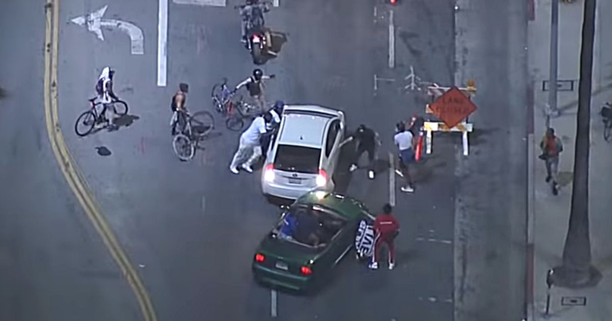 Violent protesters attack a car during unrest in Los Angeles.