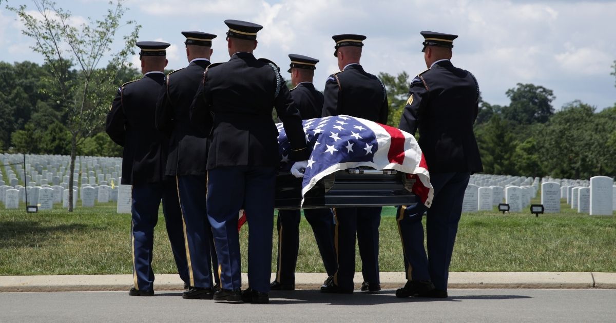 Members of the U.S. Army's 3rd Infantry Regiment carry the flag-draped casket of World War II Army veteran Carl Mann to his final resting place during his funeral on the 75th anniversary of the D-Day invasion on June 6, 2019, at Arlington National Cemetery in Arlington, Virginia.