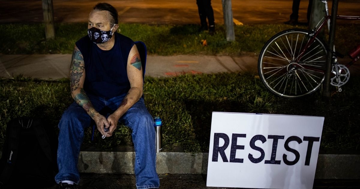 A protester sits during the sixth consecutive night of protests on Sept. 7, 2020, in Rochester, New York.