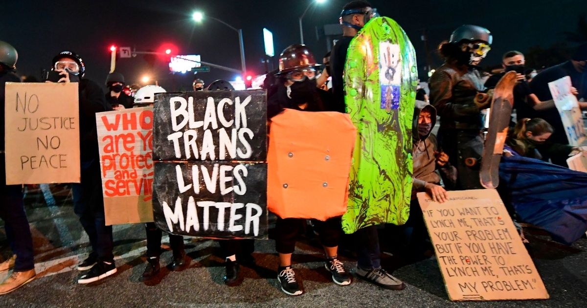 People hold placards and shields as they prepare before being dispersed by sheriff's deputies on Sept. 8, 2020, in Los Angeles.