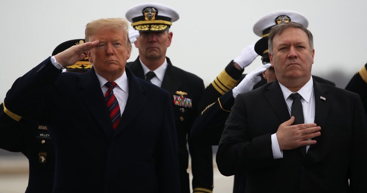 DOVER, DELAWARE - JANUARY 19: U.S. President Donald Trump salutes while joined by Secretary of State Mike Pompeo (R) as a military carry team moves the transfer case containing the remains of Scott A. Wirtz during a dignified transfer at Dover Air Force Base, January 19, 2019 in Dover, Delaware. Wirtz was a former Navy Seal who worked for the Defense Intelligence Agency and was one of four Americans killed by a suicide bomber on January 16 in Manbij, Syria.