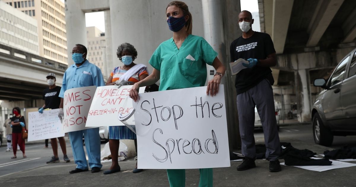 MIAMI, FLORIDA - APRIL 17: Volunteers, health care workers and doctors participate in a protest against what they say is the city's and county's poor response to helping the homeless during the coronavirus outbreak on April 17, 2020 in Miami, Florida. Dr. Henderson and several group organizations are helping the homeless by providing tests, protective masks, gloves, tents, and other items to the people in need. The groups are calling on local officials to make hotels, dorm rooms and other properties immediately available to house people; cancel all rent and mortgages; halt all evictions and end the arrest of homeless people.