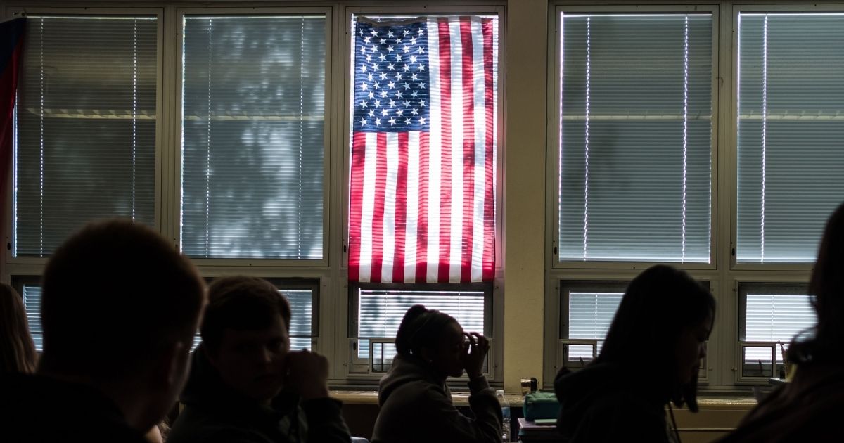 TOPSHOT - Sidney High School students sit through class under a US flag in Sidney, Ohio, October 31, 2019. - At the entrance to Sidney High School in small-town Ohio, there is a poster which reads: "Inside this building, our children are protected by an armed and trained response team." In rural Shelby County, law enforcement has trained teachers to fight back, should an attacker threaten students. They are among the first in the United States to embrace the controversial strategy.