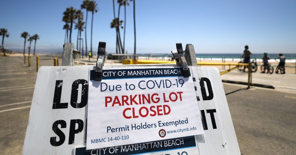 A sign from mid-summer announces that the beach at Manhattan Beach, California, is closed for the July 4 weekend because of the coronavirus pandemic.