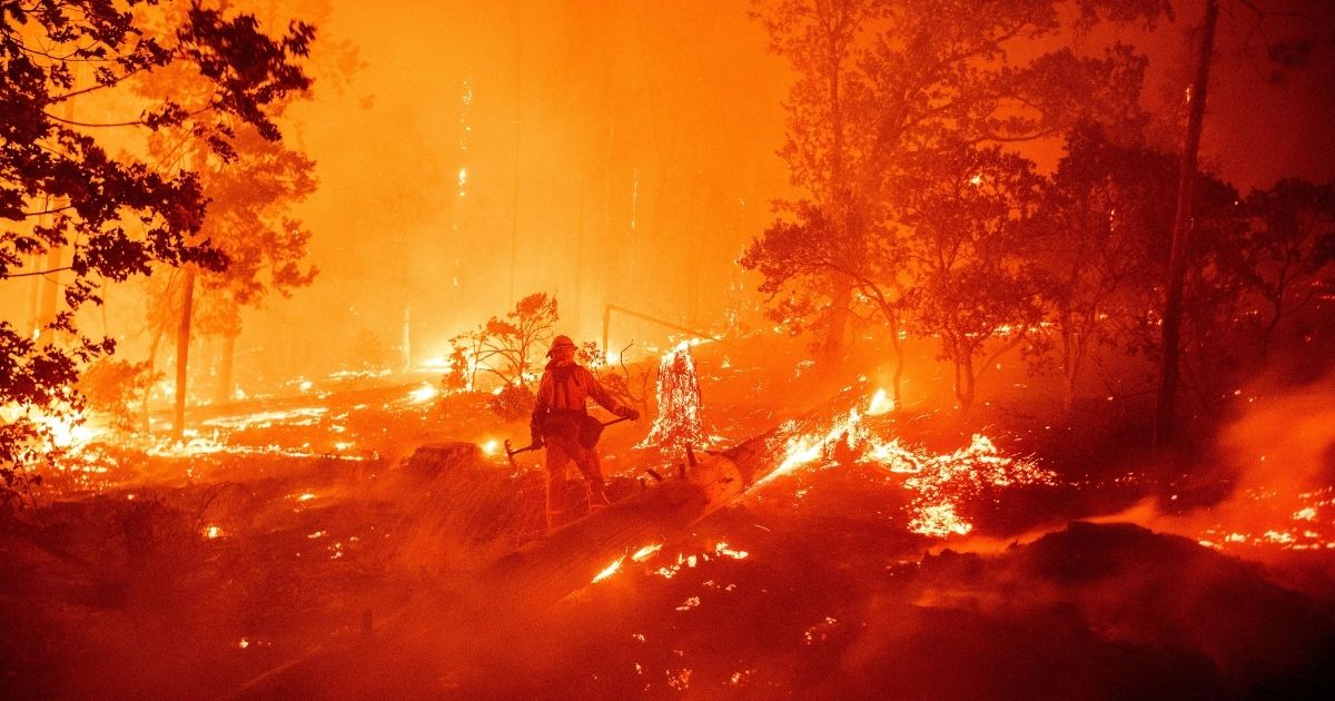 TOPSHOT - A firefighter works the scene as flames push towards homes during the Creek fire in the Cascadel Woods area of unincorporated Madera County, California on September 7, 2020. - A firework at a gender reveal party triggered a wildfire in southern California that has destroyed 7,000 acres (2,800 hectares) and forced many residents to flee their homes, the fire department said Sunday. More than 500 firefighters and four helicopters were battling the El Dorado blaze east of San Bernardino, which started Saturday morning, California Department of Forestry and Fire Protection (Cal Fire) said.
