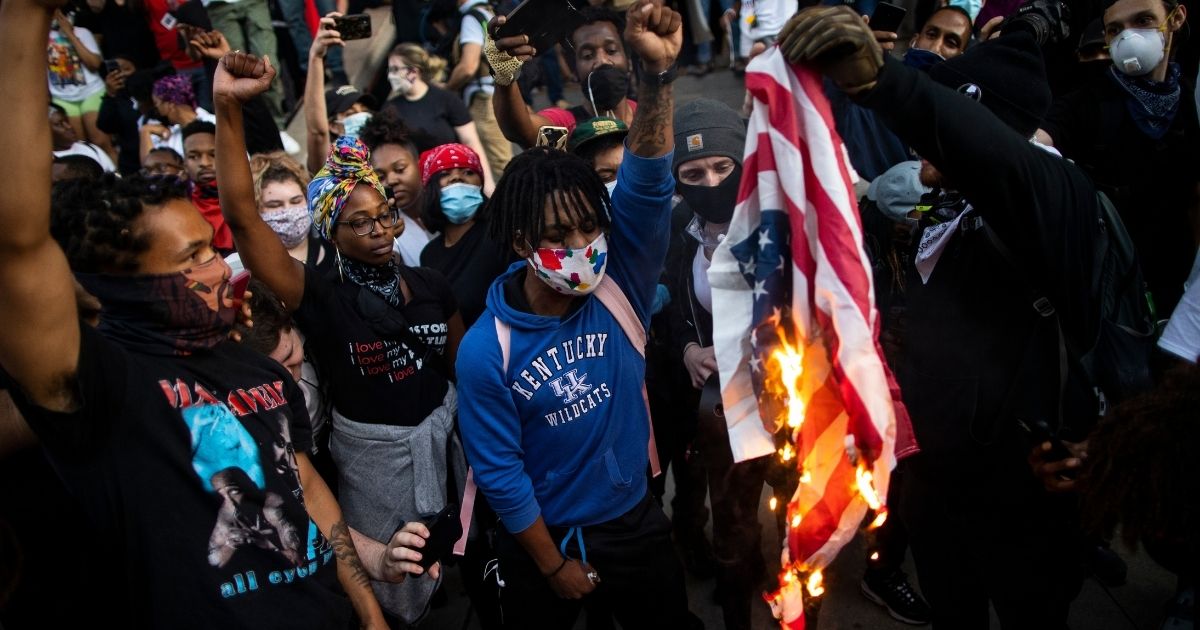 LOUISVILLE, KY - MAY 29: protesters destroy government flags outside the hall of justice on May 29, 2020 in Louisville, Kentucky. Protests have erupted after recent police-related incidents resulting in the deaths of African-Americans Breonna Taylor in Louisville and George Floyd in Minneapolis, Minnesota.